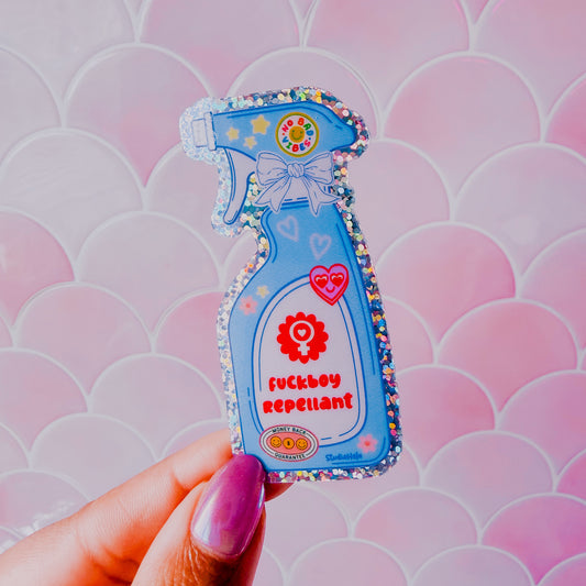 Decorative 'fuckboy repellant' product with colorful embellishments against a pink patterned background.