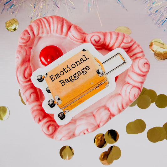 Emotional baggage luggage tag on a heart-shaped pink pillow with confetti