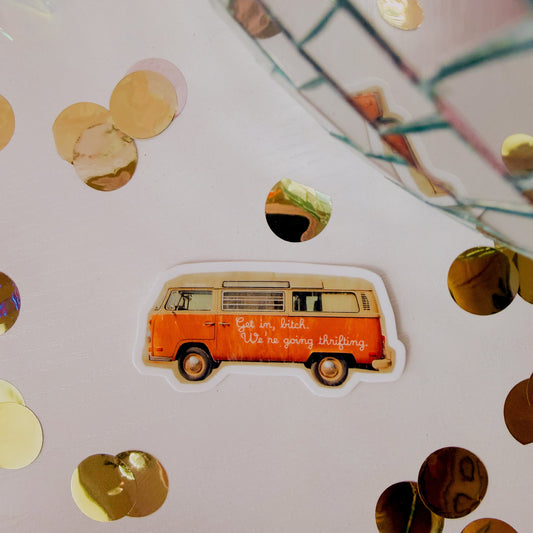 Sticker of a vintage van on a surface with gold confetti