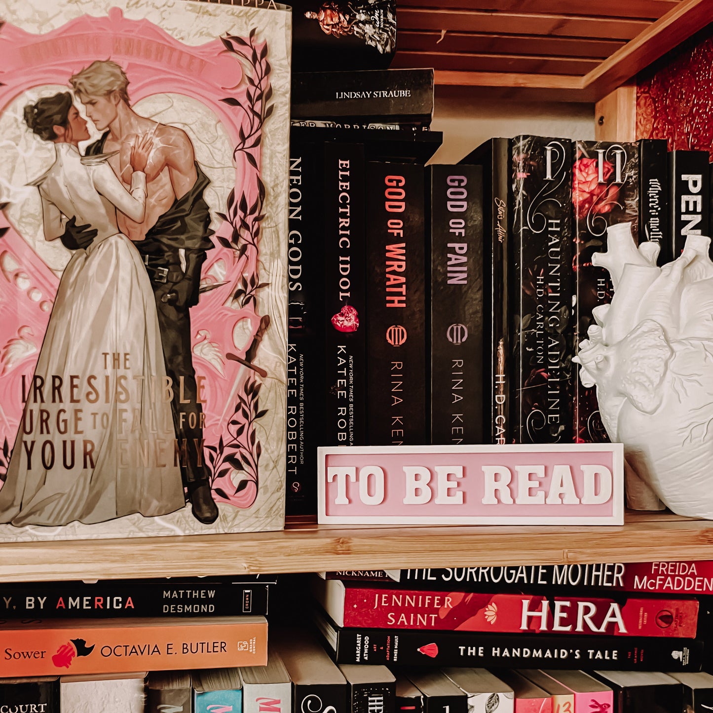 Bookshelf with books and a 'To Be Read' sign