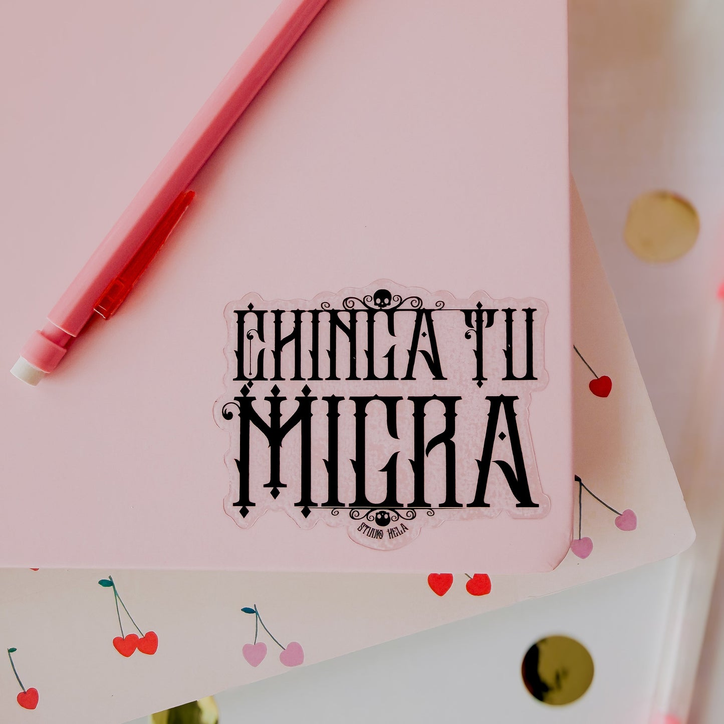 Pink paper with decorative text and red pen on a light pink background