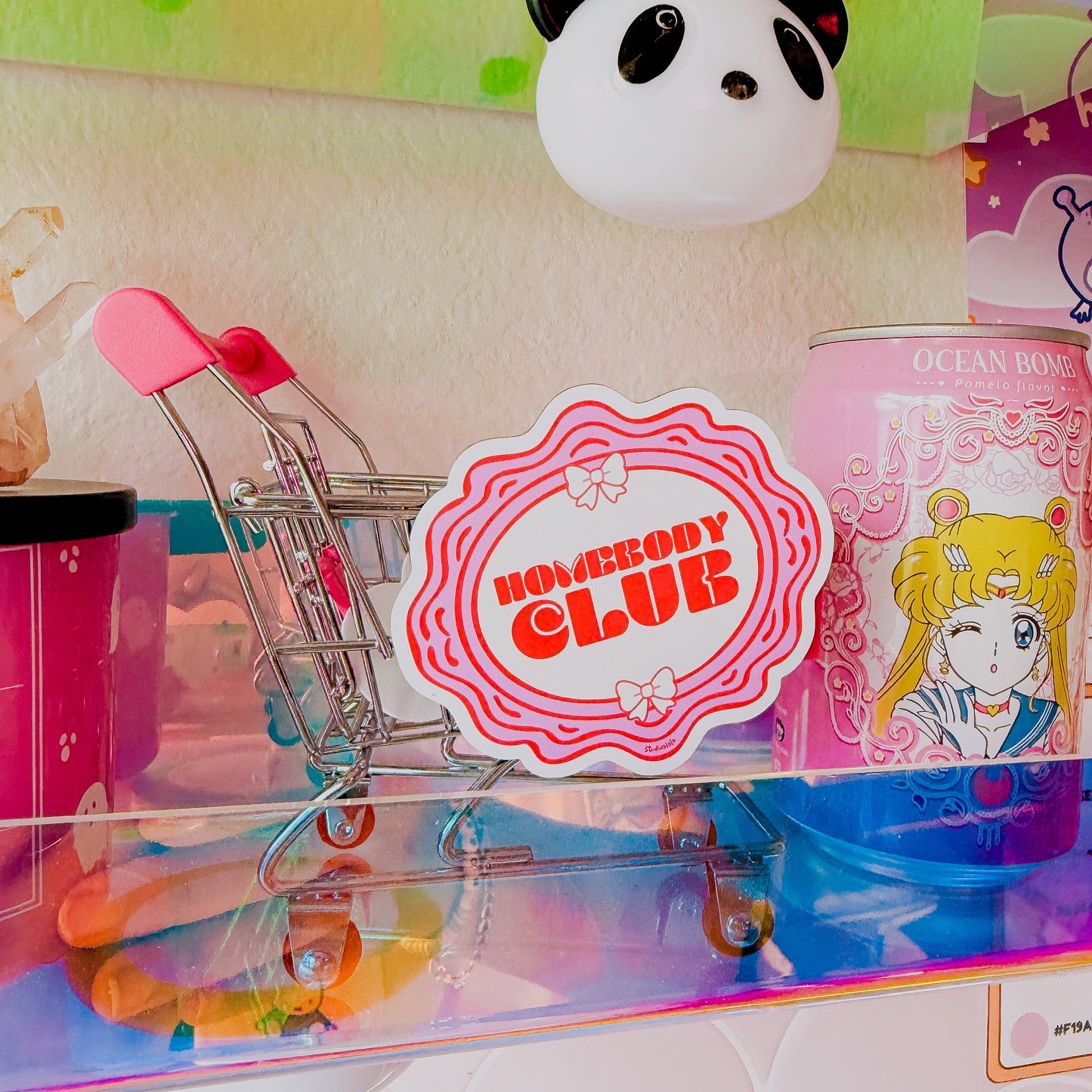 Colorful display with a panda toy, 'Nobody Club' sticker, and cartoon character can.