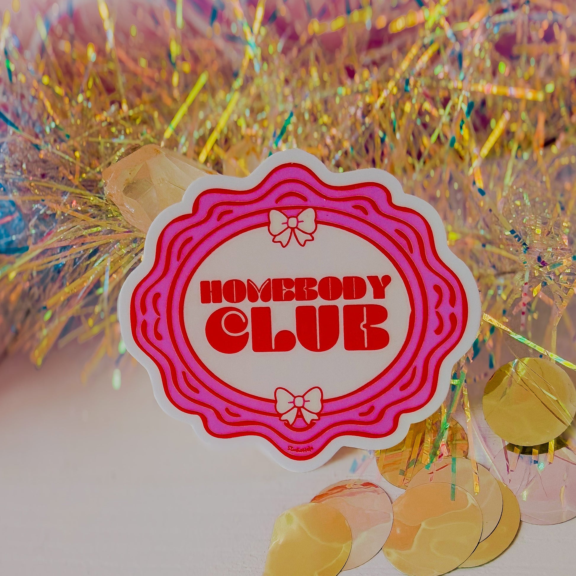 Sticker with 'HOMEBODY CLUB' text on a colorful background with confetti