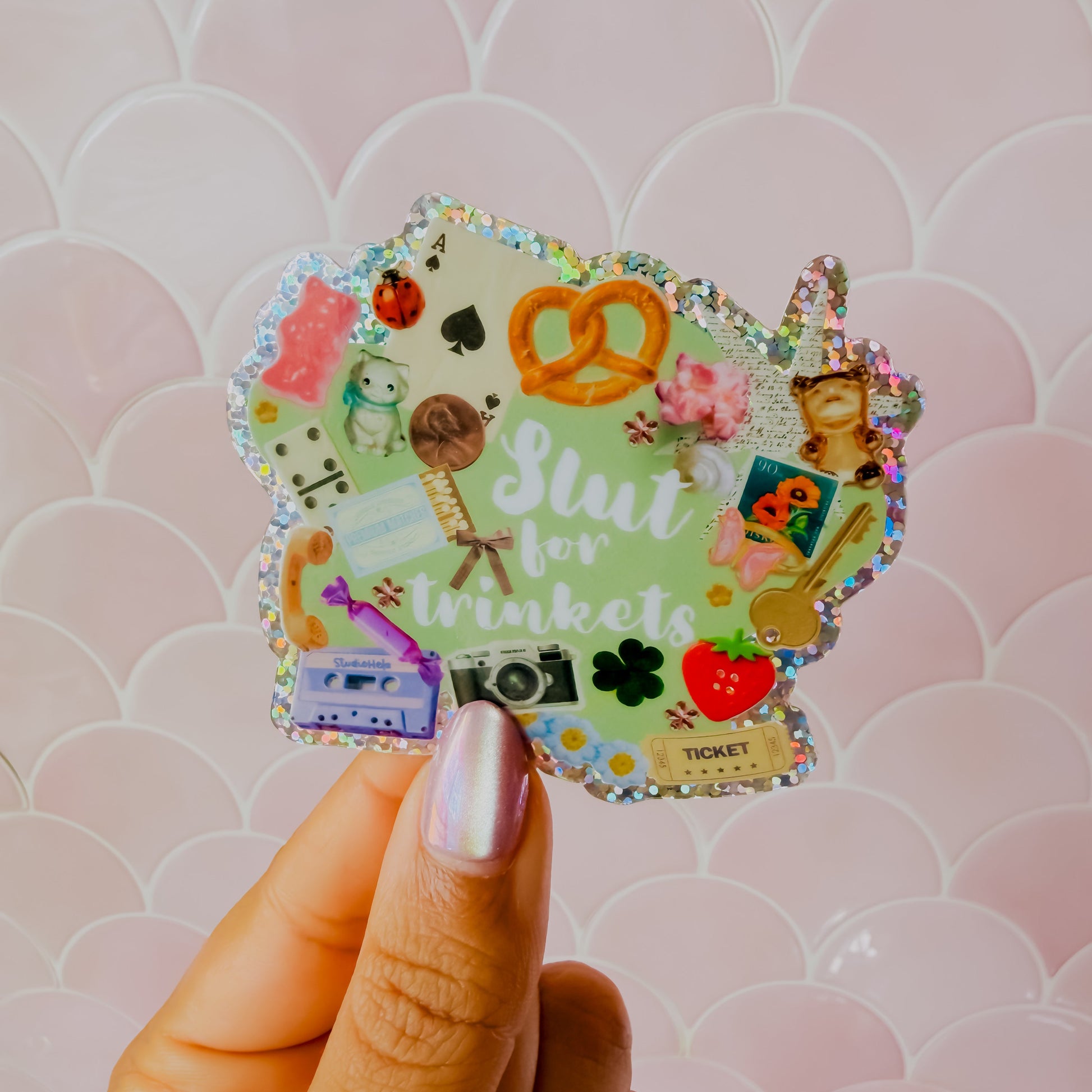 Hand holding a colorful sticker with text against a patterned background