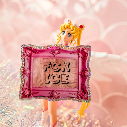 Animated character with a pink frame displaying 'FCK ICE' against a blurred background.