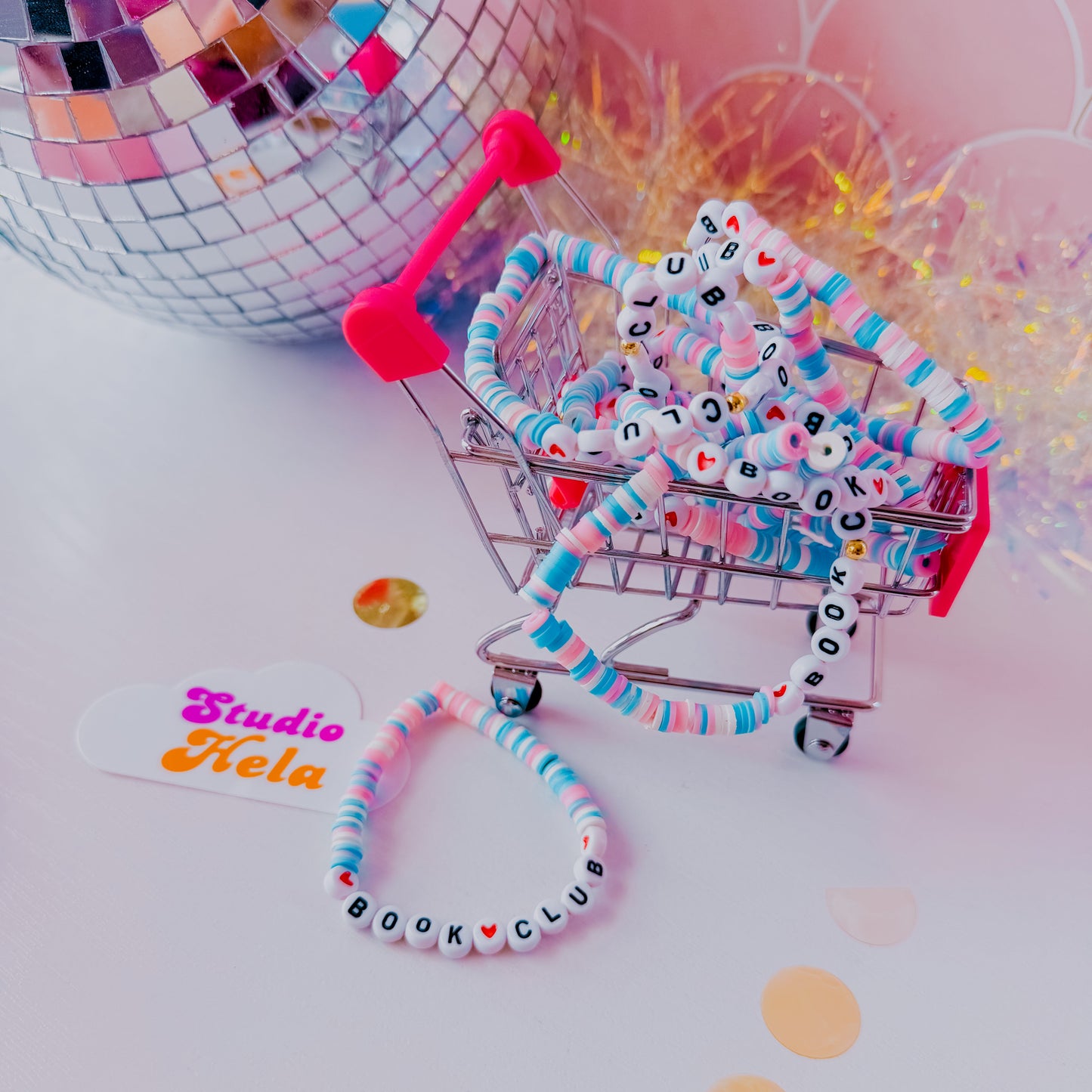 Colorful keychain with text and a small shopping cart toy on a light background
