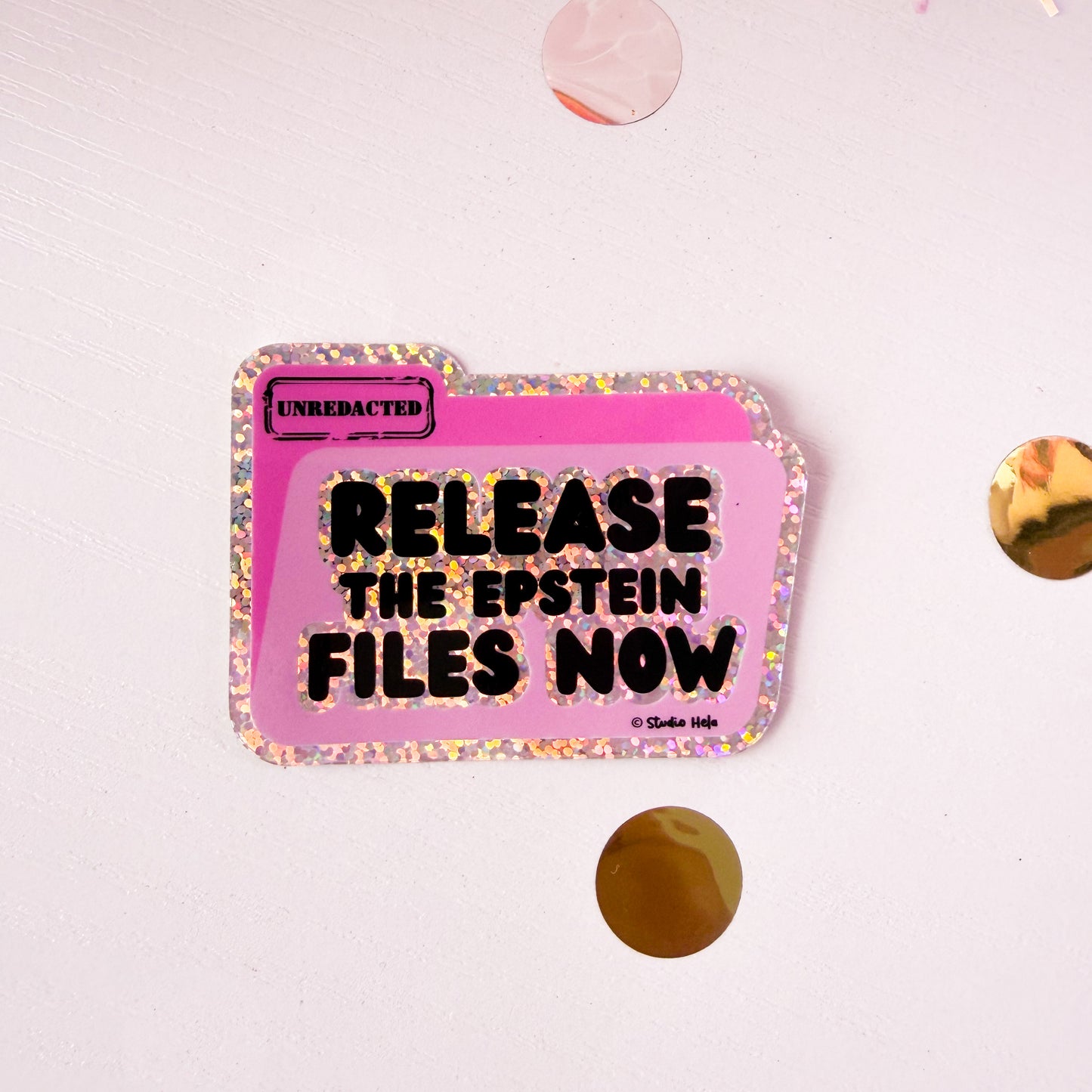 Pink folder with 'Release the Epstein Files Now' text on a white background with gold confetti.