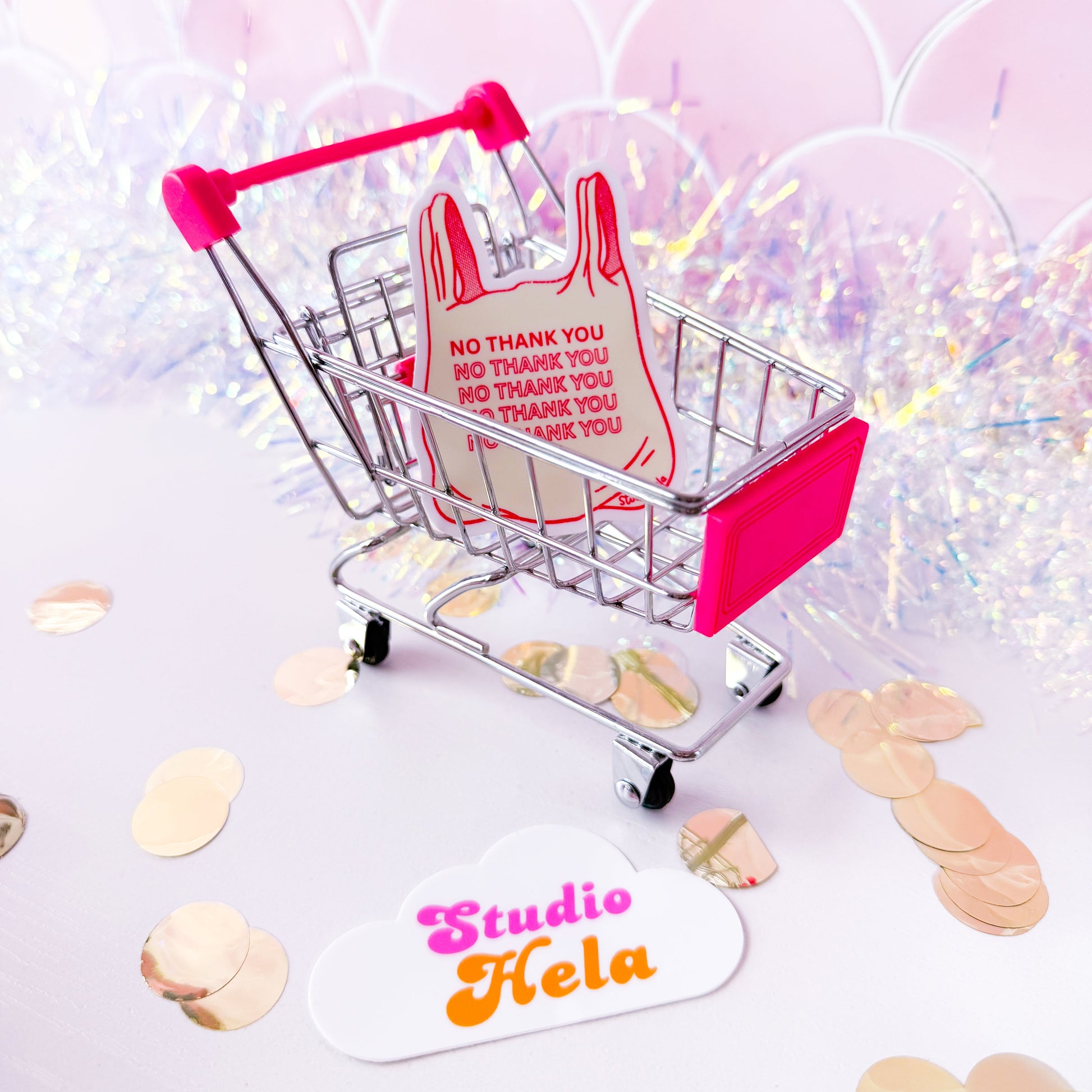 Small shopping cart with a dress and 'thank you' cards on a light background with confetti.