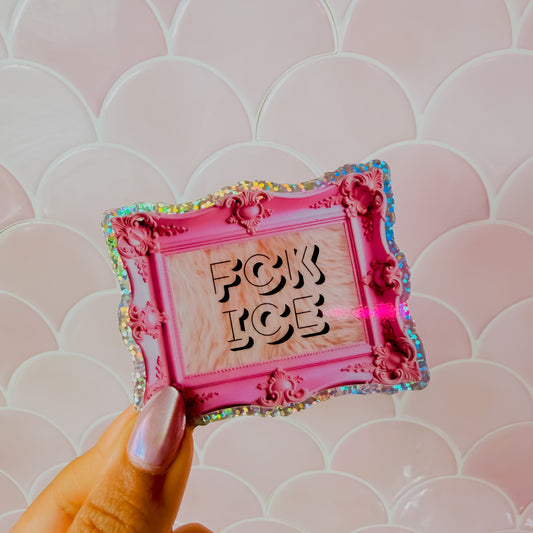 Pink framed sticker with 'FCK ICE' text held against a pink patterned background