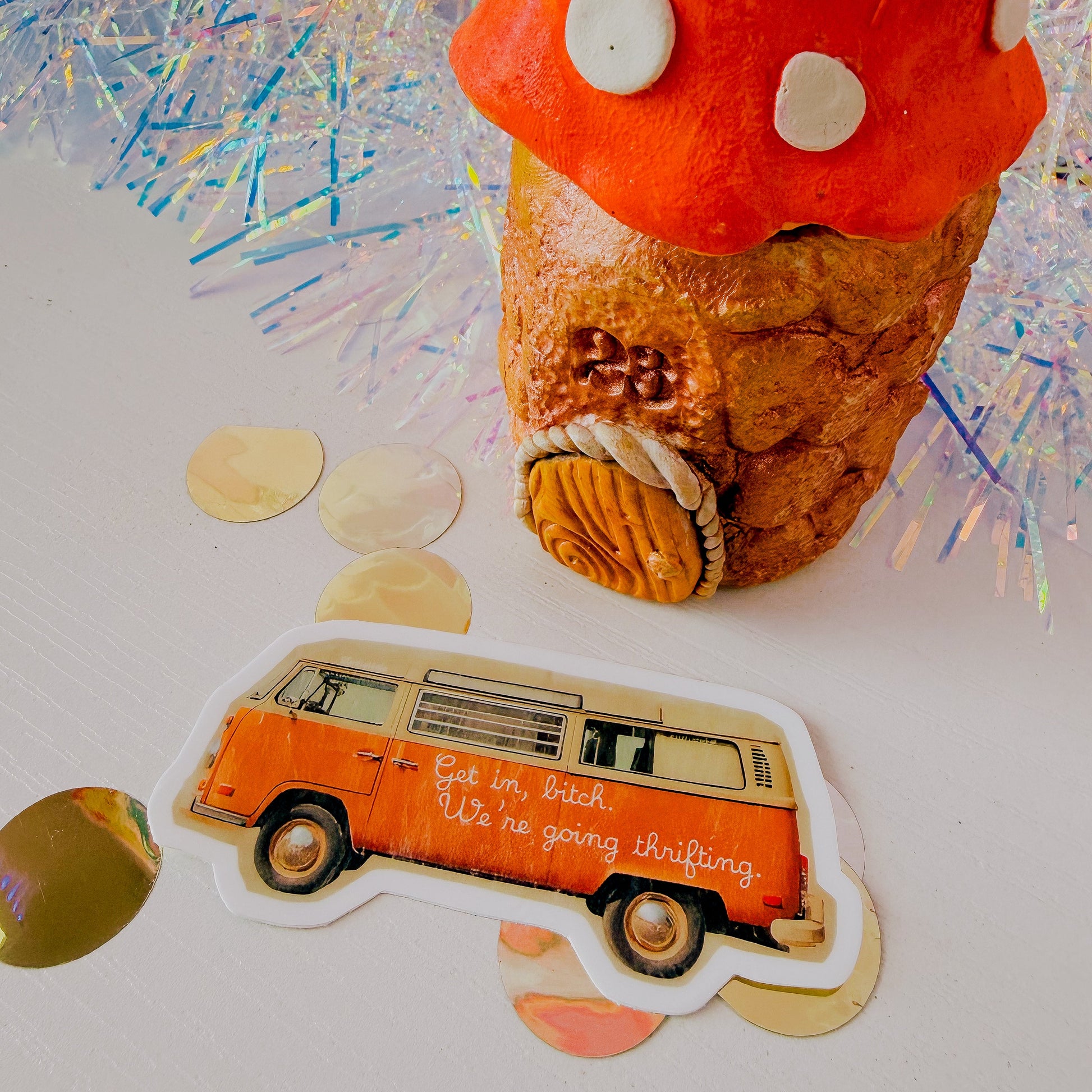 Decorative mushroom-shaped object with a sticker of an orange van on a colorful background