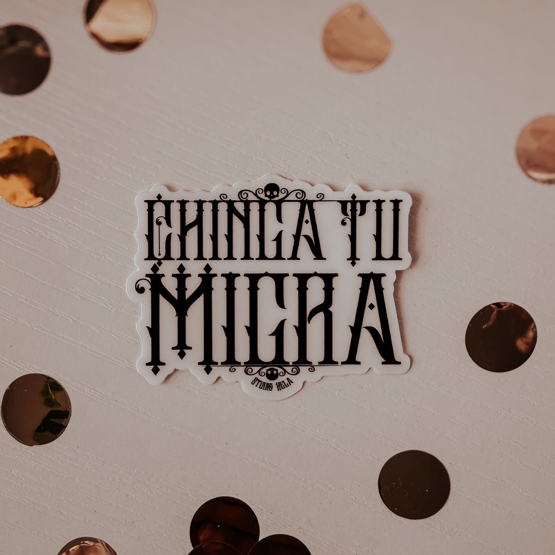 Sticker with 'Ehnicatii Milera' text on a textured surface with circular patterns.