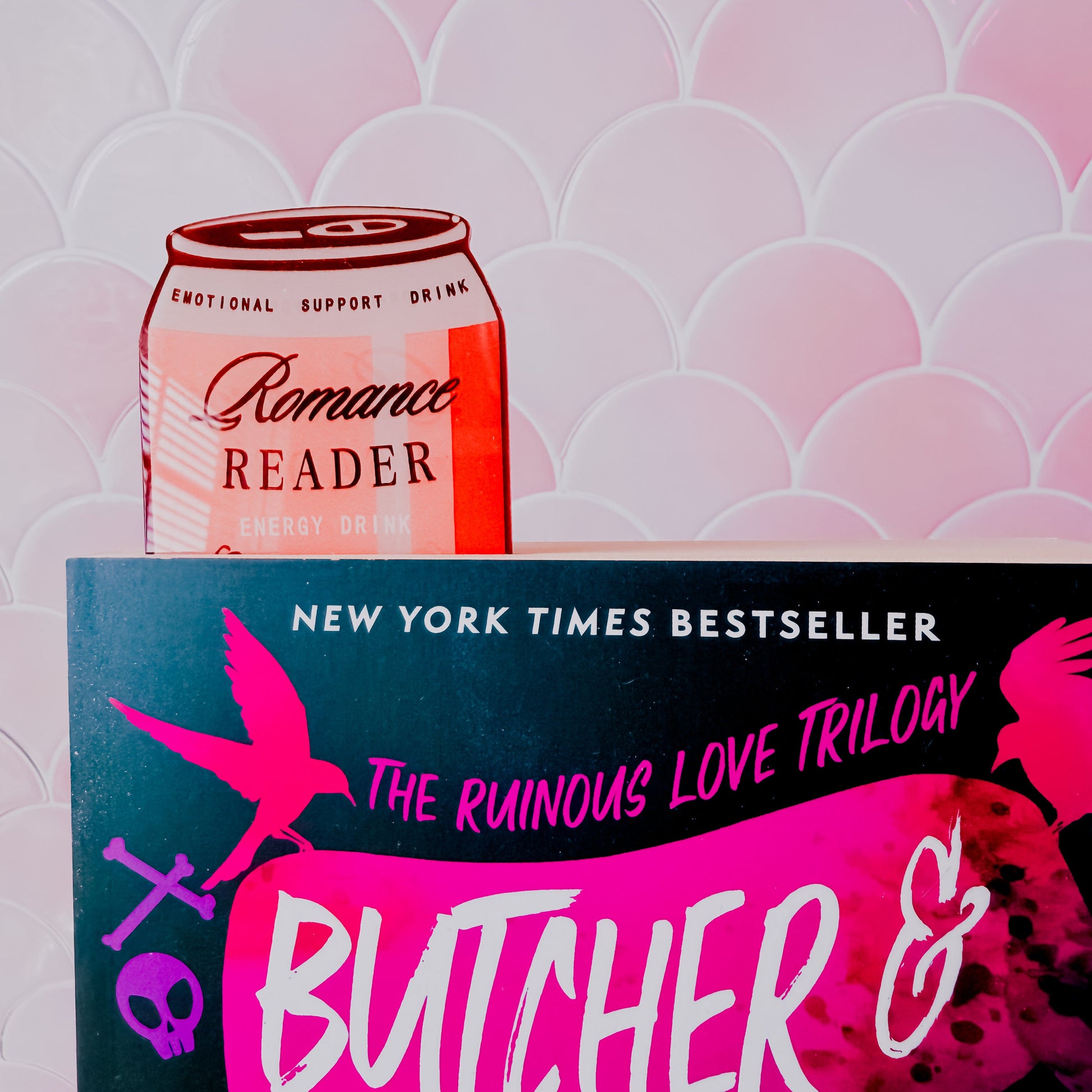 Book titled 'Butcher &' with a can of 'Romance Reader' on a patterned background