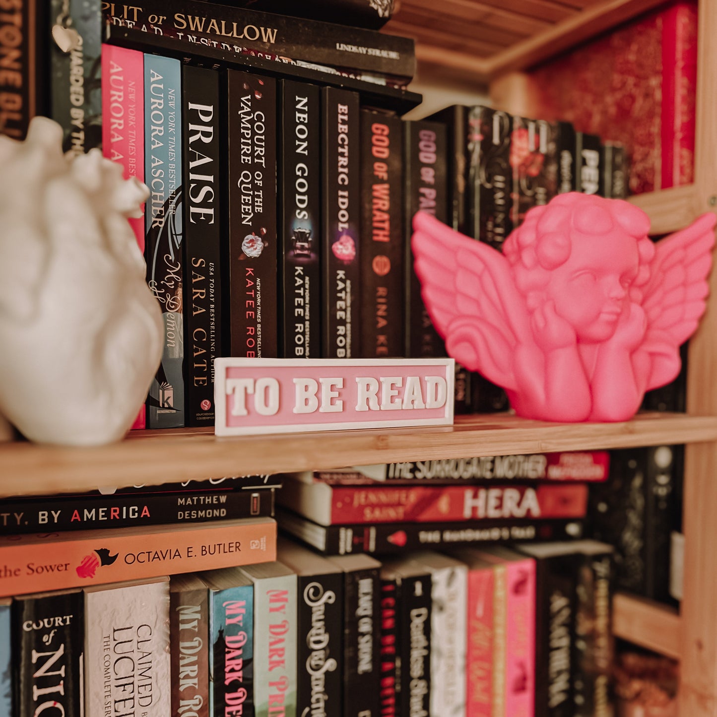 Bookshelf with books and decorative items including a pink angel figurine.